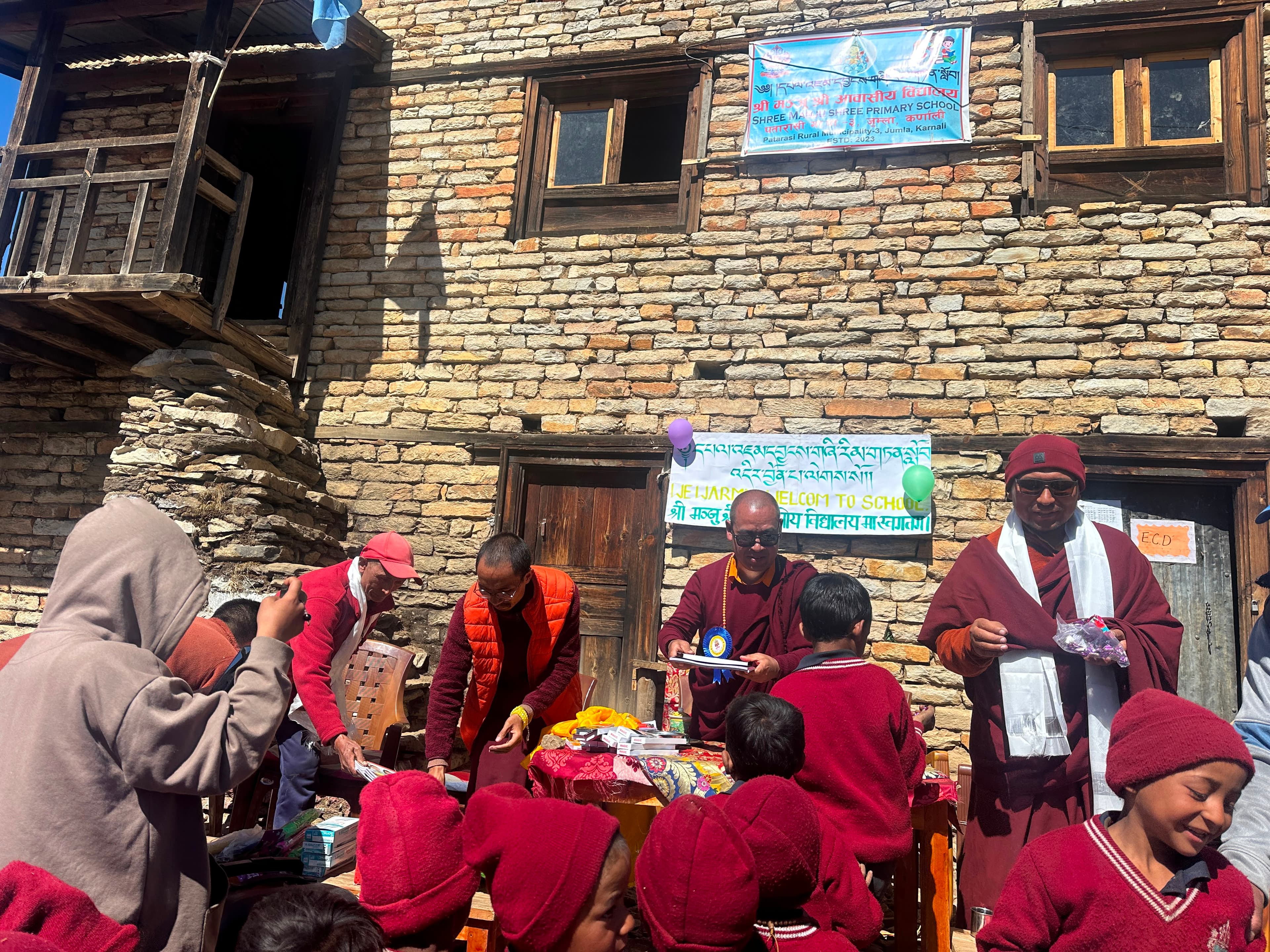 Volunteers and monks hand out gifts and supplies to students during our opening ceremony.